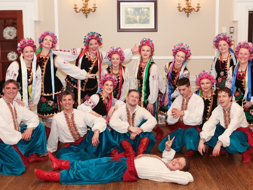 Vesnianka Ukrainian Dance Ensemble wearing traditional Ukrainian clothes: red boots, embroidered shirts, flower crowns for girls and wide pants for guys.