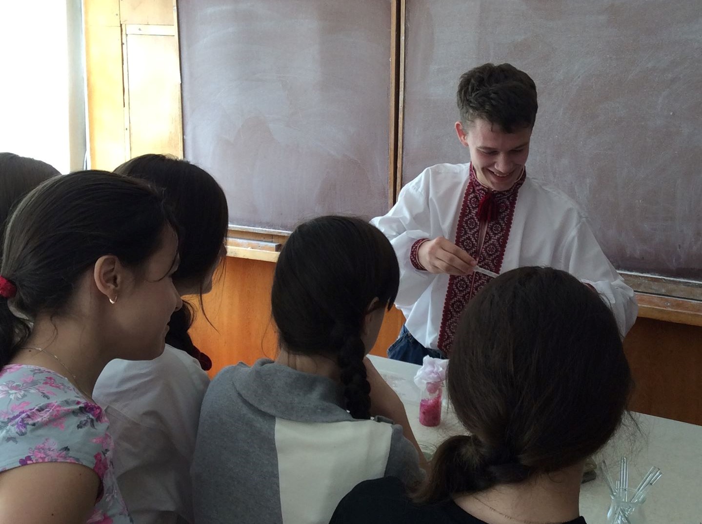 Roman is demonstrating the concert of pH indicators using the cabbage extract to a group of middle school students in Lutsk