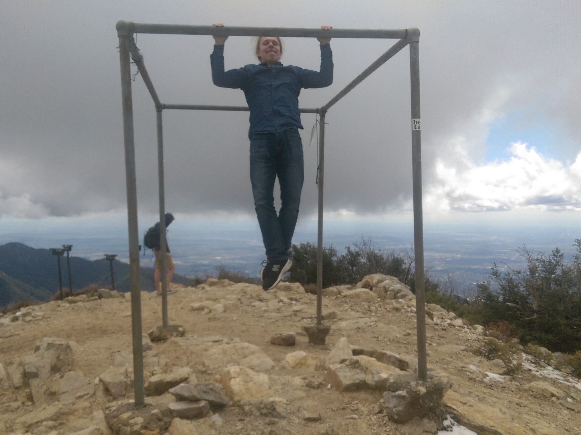 Roman is doing a pull-up on top of the mountain