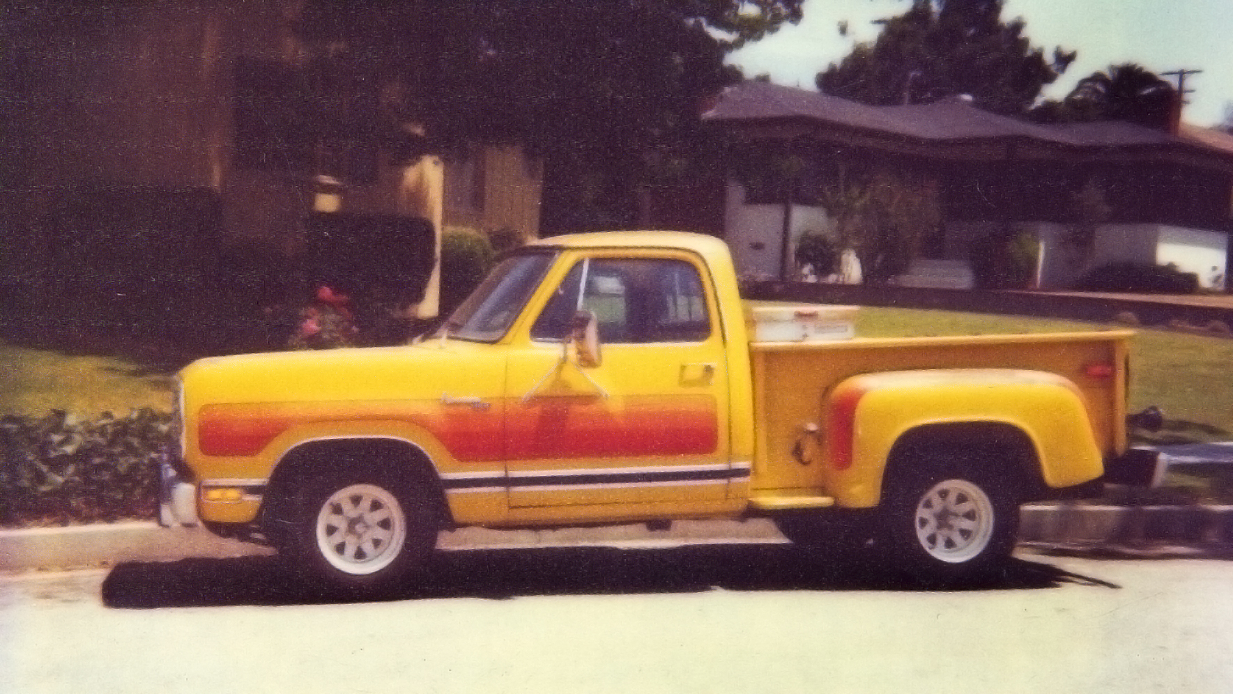 Yellow Dodge D-100 Pickup with Exaust Stacks orange stripes in 1984